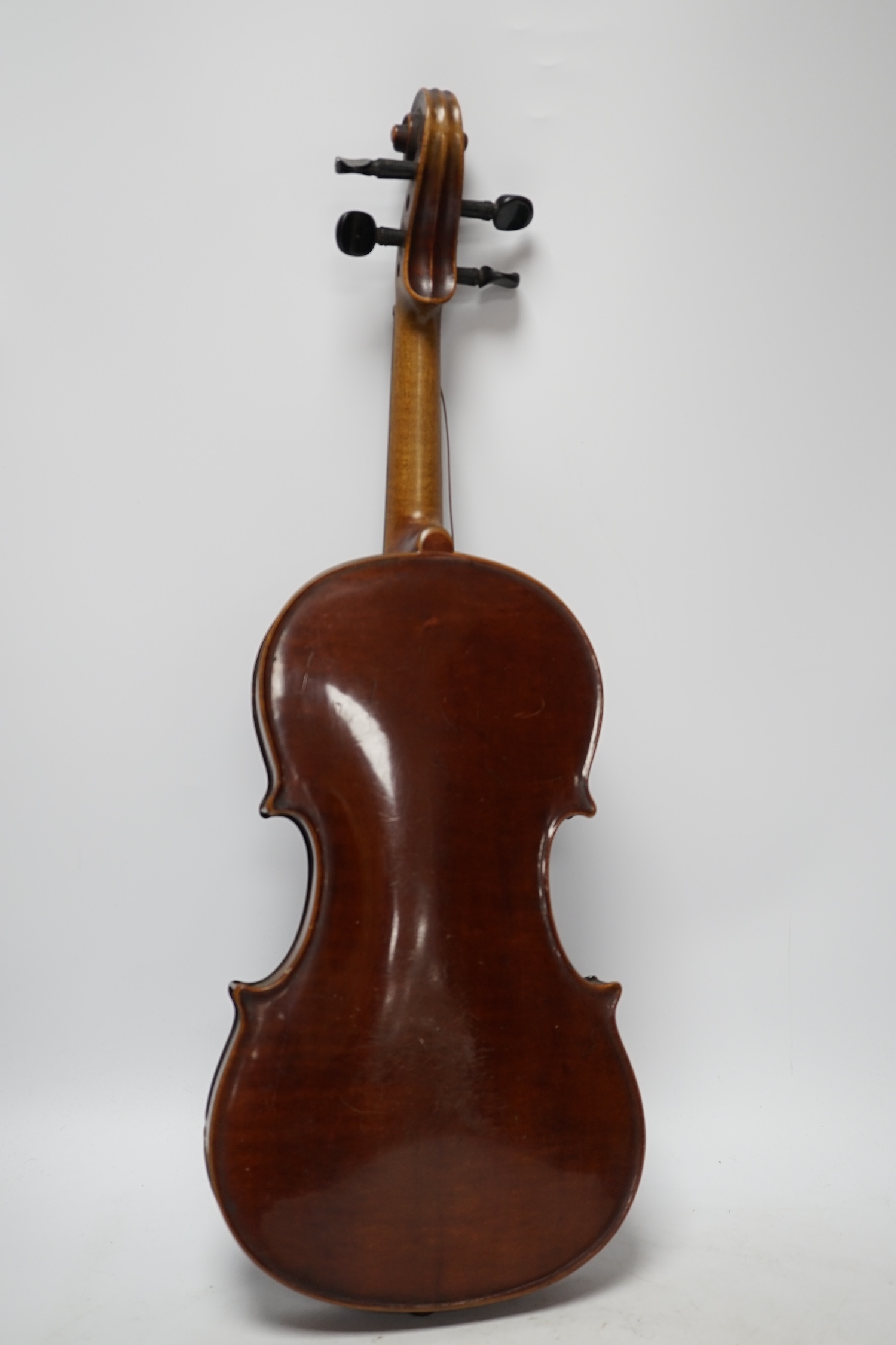 A late 19th century three quarter length violin with label; 'Medio-Fino', back measures 33cm. Condition - fair